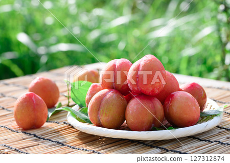 閃閃發光的水滴梅子和竹籃 夏季水果圖片（早期） 127312874