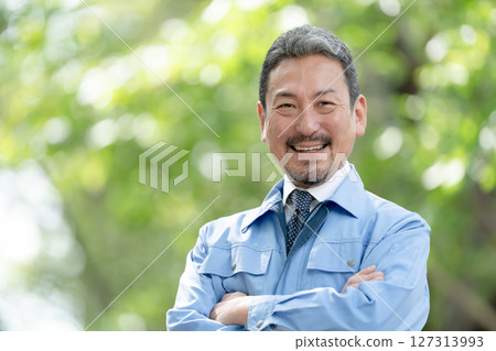穿著工作服、清新綠色、雙臂交叉的男人 127313993
