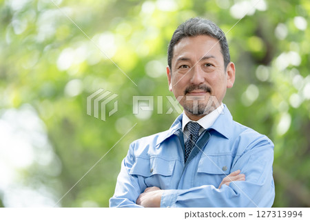 Man in work clothes, fresh green, arms crossed 127313994