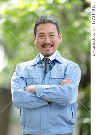 穿著工作服、清新綠色、雙臂交叉的男人 127314012