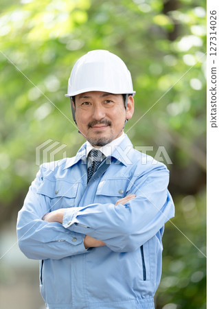 穿著工作服、清新綠色、雙臂交叉的男人 127314026