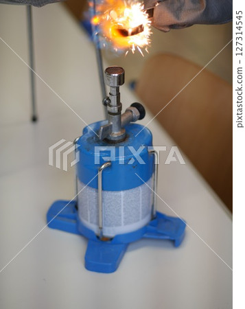 Blue container with a flame on top of it Blue container with a flame on top of it 127314545