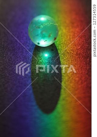 Small, glowing ball sits on a dark surface Small, glowing ball sits on a dark surface 127314559