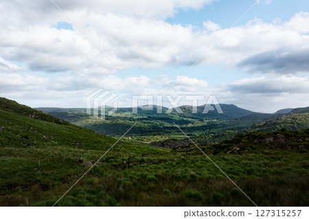 Serene Irish landscape unfolds, rolling green hills meet a bright sky. Peaceful valley bathed in sunlight. Serene Irish landscape unfolds, rolling green hills meet a bright sky. Peaceful valley bathed in sunlight. 127315257