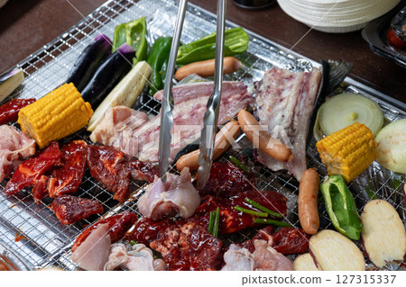 Grilling meat and vegetables on a barbecue 127315337