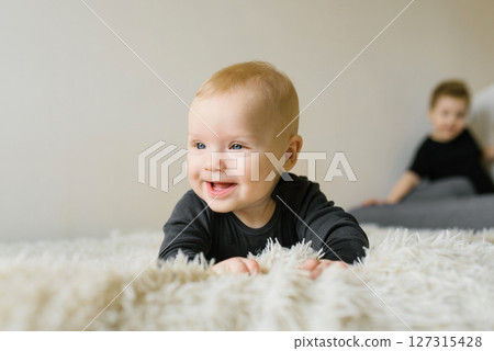 Siblings Playing On White Rug 127315428