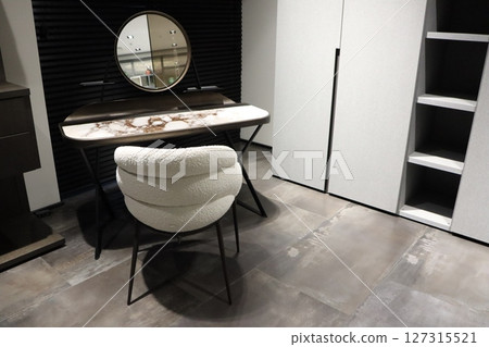 A stylish vanity with a round mirror and minimalist design, creating a warm, inviting space A stylish vanity with a round mirror and minimalist design, creating a warm, inviting space 127315521