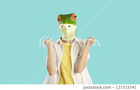 Happy humorous excited woman in frog mask rejoices in success and triumphantly clenched fists. 127315541