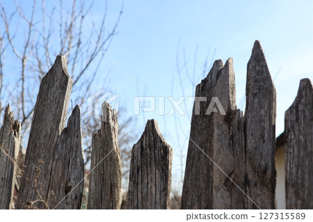 A Weathered Wooden Fence Set Against a Beautiful Clear Sky Background with Vibrant Colors 127315589