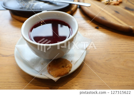 Enjoy a Delicious Berry Infusion paired with a Scrumptious Cookie on a Wooden Table Enjoy a Delicious Berry Infusion paired with a Scrumptious Cookie on a Wooden Table 127315622