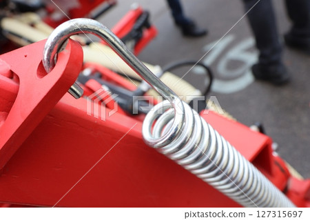 A CloseUp Image of a Metal Coil Spring Within a Piece of Machinery and Equipment 127315697