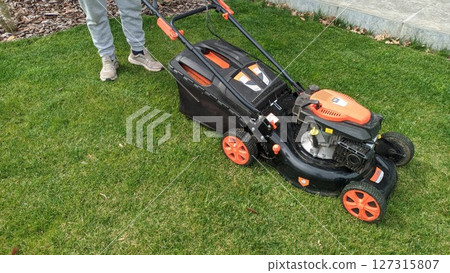 A Lawn Mower Positioned on Grass, All Set for a Comprehensive Maintenance Procedure A Lawn Mower Positioned on Grass, All Set for a Comprehensive Maintenance Procedure 127315807