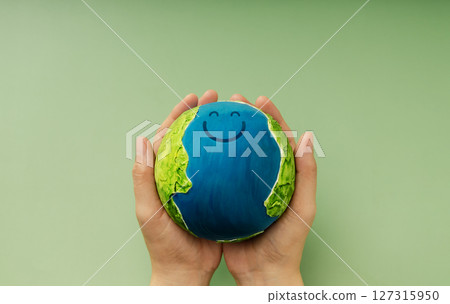 Happy Earth in hands symbolizing sustainability, global happiness, environmental care, and ecological responsibility 127315950