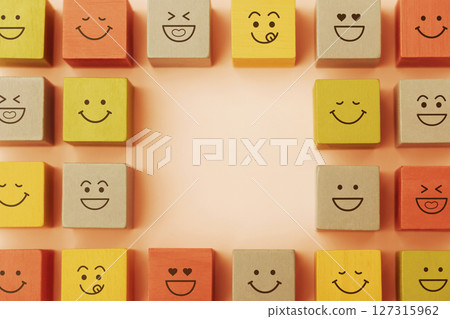Happy Concepts. World Happiness Day, International Smiling Day. Mind and mental Health. Smiling Emoticon Face on Yellow Orange Cube. Table Top View with Copy space 127315962