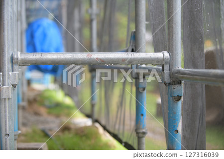 Scaffolding at a construction site wet from the rainy season Scaffolding at a construction site wet from the rainy season 127316039