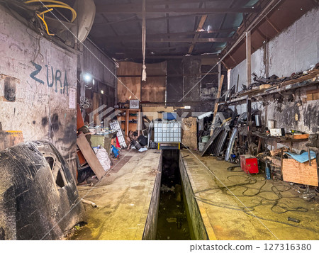 An auto mechanic workshop packed with tools, wires, and metal parts shows real industrial grit and functional chaos 127316380