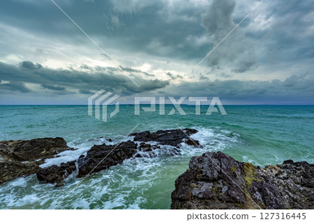 Beautiful scene of the sea and sky blending together at Kannonzaki, Ishigaki Island. Rainy season sky. Long shutter view. 127316445
