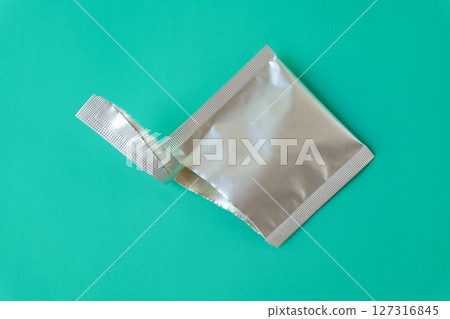 Open aluminum bag lying on color background. 127316845