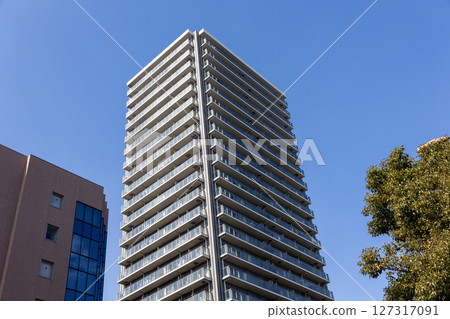 High-rise apartment building seen from below against the blue sky High-rise apartment building seen from below against the blue sky 127317091