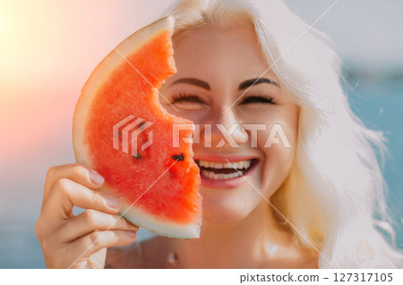 Watermelon Woman Summer Beach: Happy woman enjoys watermelon slice near ocean during summer. Watermelon Woman Summer Beach: Happy woman enjoys watermelon slice near ocean during summer. 127317105