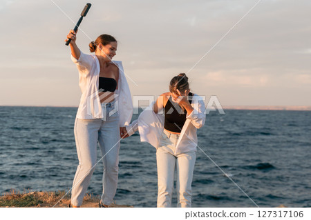 Beach Women Friends Fun - Two women are laughing and having fun on the beach at sunset. 127317106