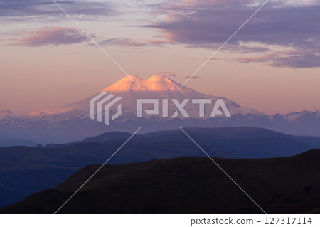 Elbrus Sunset Mountains: Peaks lit at dusk for iconic landscape view Caucasus. Elbrus Sunset Mountains: Peaks lit at dusk for iconic landscape view Caucasus. 127317114