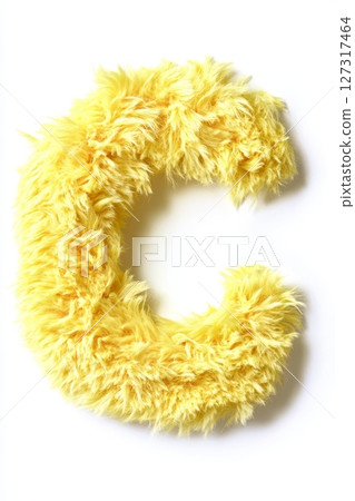 The fluffy yellow letter C stands out against a pure white background, showcasing its soft and inviting texture 127317464