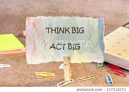 THINK BIG ACT BIG concept words written on paper, fixed in a clothespin 127318251