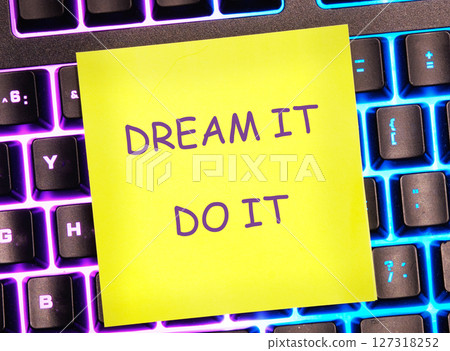Motivational words DREAM IT, DO IT written on a bright yellow sticker on a colorful keyboard Motivational words DREAM IT, DO IT written on a bright yellow sticker on a colorful keyboard 127318252