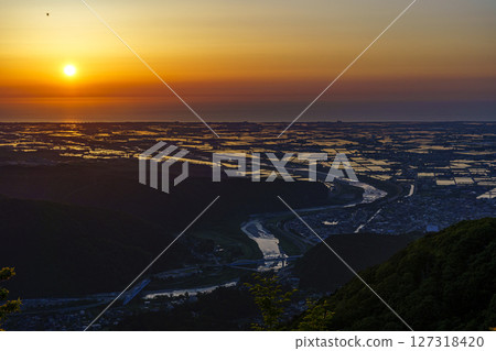 The rice fields of the Tedori River alluvial fan and the Sea of Japan as seen from the Saikaku Forest Road in the setting sun The rice fields of the Tedori River alluvial fan and the Sea of Japan as seen from the Saikaku Forest Road in the setting sun 127318420