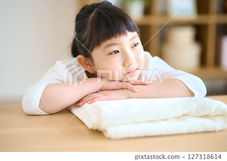 Elementary school girl lying down on a towel and relaxing 127318614