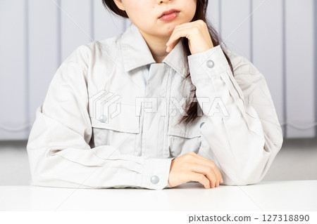 Asian woman worried about wearing work clothes 01 127318890