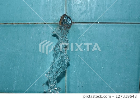 water splashing from broken plumbing blue polythene pipe line in bathroom 127319648