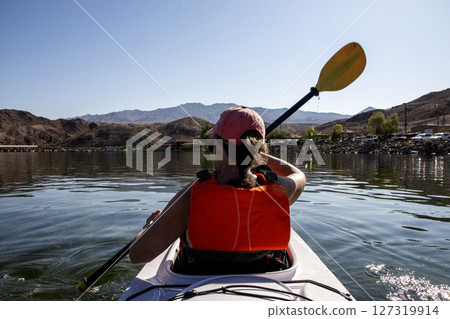Kayaker Paddling on Calm Water Surrounded by Mountains Kayaker Paddling on Calm Water Surrounded by Mountains 127319914