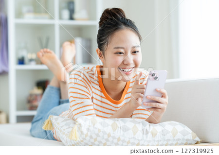 年輕女子在客廳看智慧型手機 127319925