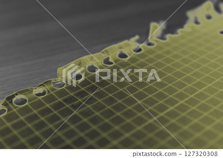 Yellow notebook page resting on desk with torn edge Yellow notebook page resting on desk with torn edge 127320308