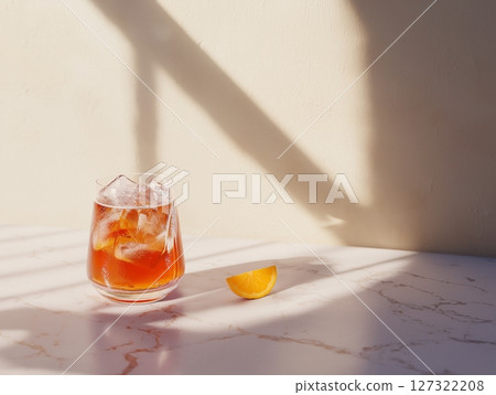 Aperol Spritz cocktail with orange slice, ice, and bubbles on natural neutral background, sunlight shadows. 127322208