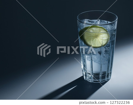 Glass of sparkling water with lime on gray background, sharp contrast lighting, fresh and crisp. 127322236