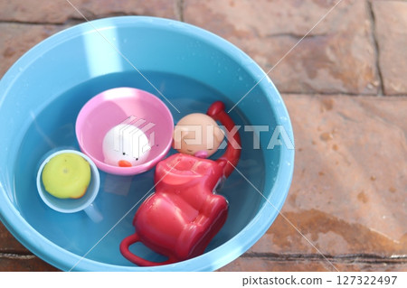 A basin of water and a floating toy 127322497