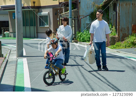A family of four walking through a residential area on a sunny day A family of four walking through a residential area on a sunny day 127323090