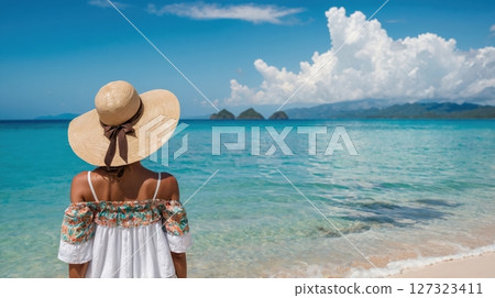 a young woman in white dress looking at the sea 127323411