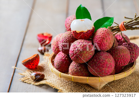 fresh ripe lychees in a bamboo basket with green leaves fresh ripe lychees in a bamboo basket with green leaves 127323917