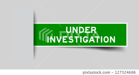 Green color square label sticker with word under investigation that inserted in gray background 127324686