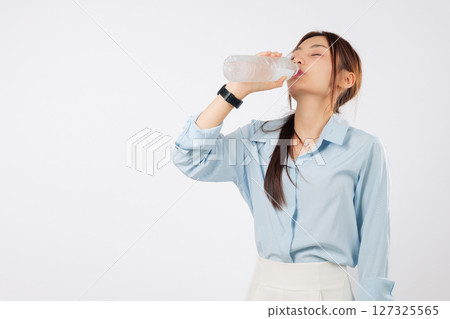 Young woman water bottle drink, asian girl hold plastic water bottle with closed eyes enjoy a healthy drink, hydration fresh lifestyle concept and positive smile, isolated studio white background 127325565