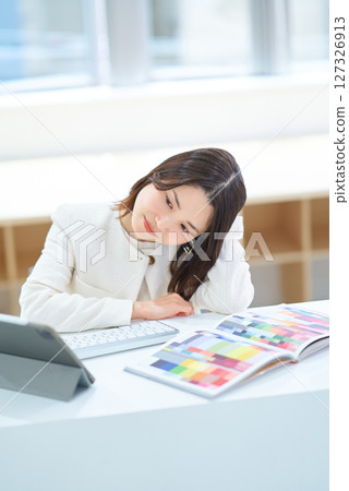 A woman looking tired while working on a computer 127326913