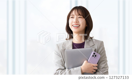 Smiling woman with a laptop and smartphone 127327133