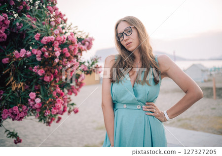 Elegant Woman Posing with Pink Flowers Outdoors 127327205