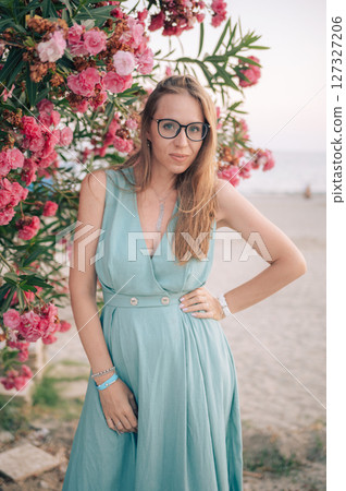 Elegant Woman Posing with Pink Flowers Outdoors 127327206