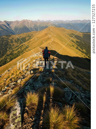 Backpackers Shadow Stretching Across Rocky Mountain Ridge at Sunset Adventure 127327235