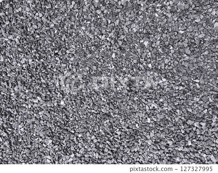 A horizontal stock image of many small dark gray crushed stones laid out 127327995